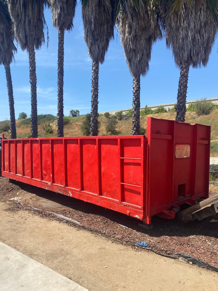 Red Heverly & Sons roll-off dumpster under San Diego palm trees